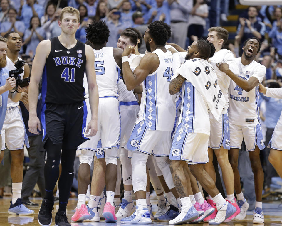 North Carolina players celebrate while Duke's Jack White (41) walks away following an NCAA college basketball game in Chapel Hill, N.C., Saturday, March 9, 2019. North Carolina won 79-70. (AP Photo/Gerry Broome)