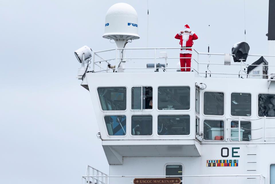Santa Claus signals to community members attending the send-off party to cover their ears before the ship's horn sounds Sunday, Nov. 26, 2023.