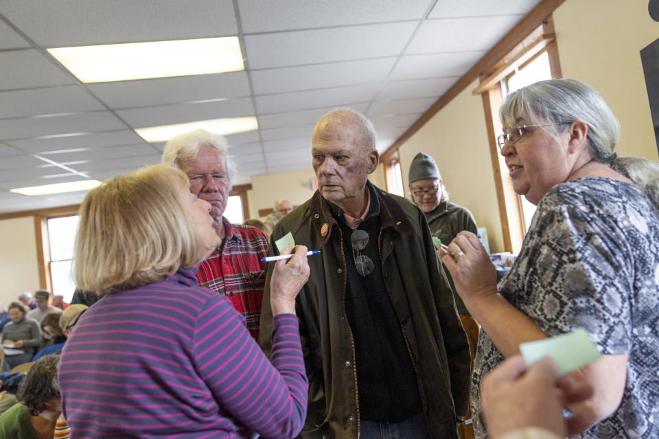 Los residentes discuten el proceso de votación sobre un tema que ha surgido en la asamblea anual del pueblo de Elmore, Vermont, el martes 5 de marzo de 2024. La asamblea municipal es una tradición que, en Vermont, se remonta a hace más de 250 años, antes de la fundación de la república. Pero está amenazada. Muchas personas consideran que ya no tienen tiempo o capacidad para asistir a esas reuniones. El año pasado, los residentes de la vecina Morristown votaron a favor de cambiar a un sistema de votación secreta, poniendo fin a su tradición de asamblea municipal. (AP Foto/David Goldman)