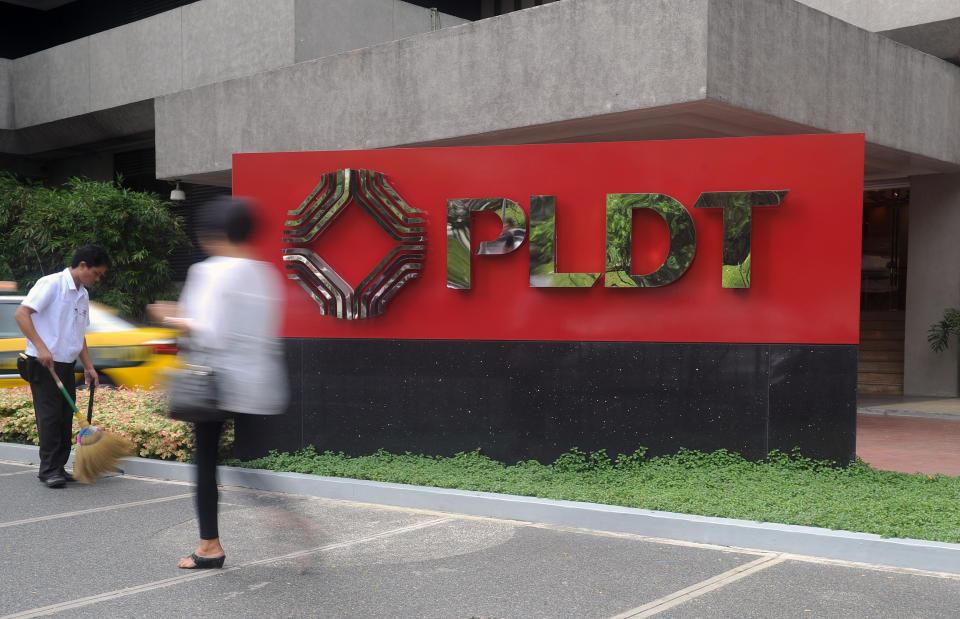 FILE PHOTO: A pedestrian walks past the Philippine Long Distance Telephone (PLDT) logo in Manila's financial district. (Photo: JAY DIRECTO/AFP via Getty Images)