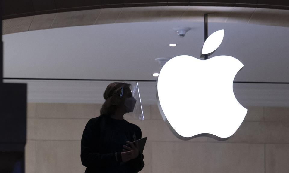 An Apple store employee wears personal protective equipment in New York. - Credit: AP