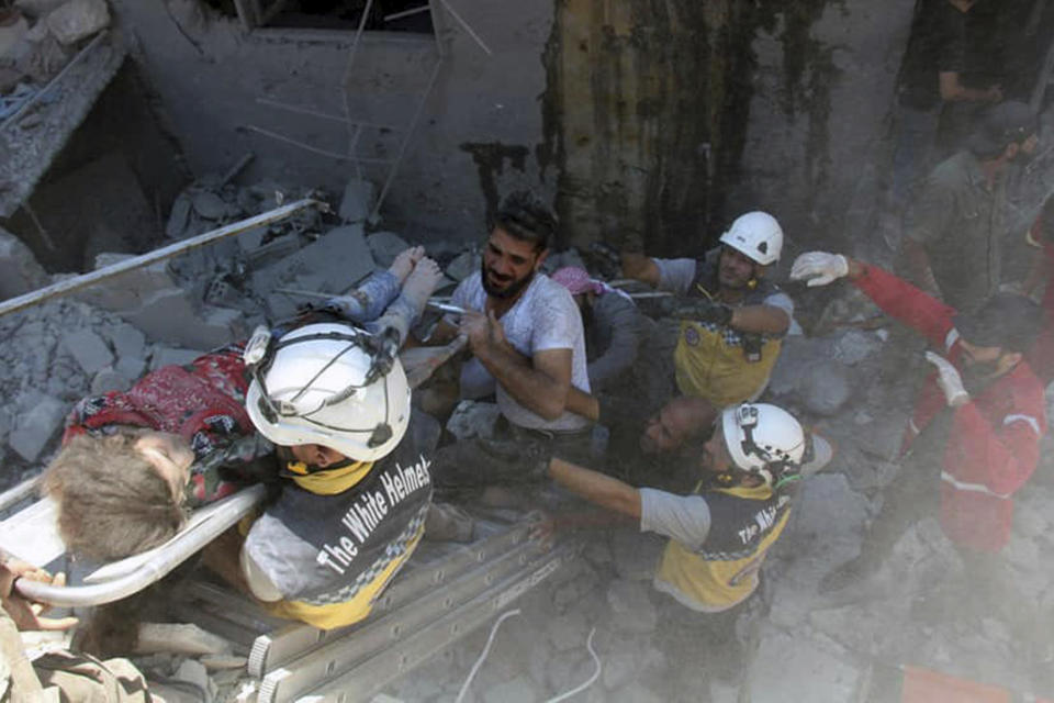 This photo provided by the Syrian Civil Defense White Helmets, which has been authenticated based on its contents and other AP reporting, shows Syrian White Helmet civil defense workers carry an injured girl on a stretcher after an airstrike hit the northern town of Ariha, in Idlib province, Syria, Saturday, July 27, 2019. Syrian activists and a doctor say a government airstrike killed several people when it hit a weekly open-air market in a busy town in the last rebel stronghold in northwestern Syria. (Syrian Civil Defense White Helmets via AP)