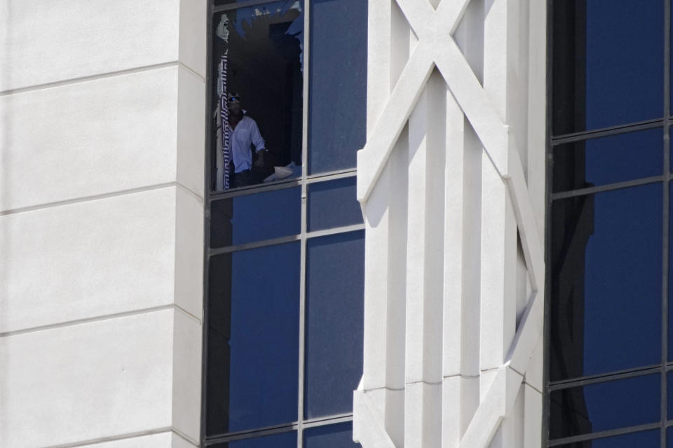 A person looks out a broken window on a hotel tower at Caesars Palace hotel-casino, Tuesday, July 11, 2023, in Las Vegas. (AP Photo/John Locher)