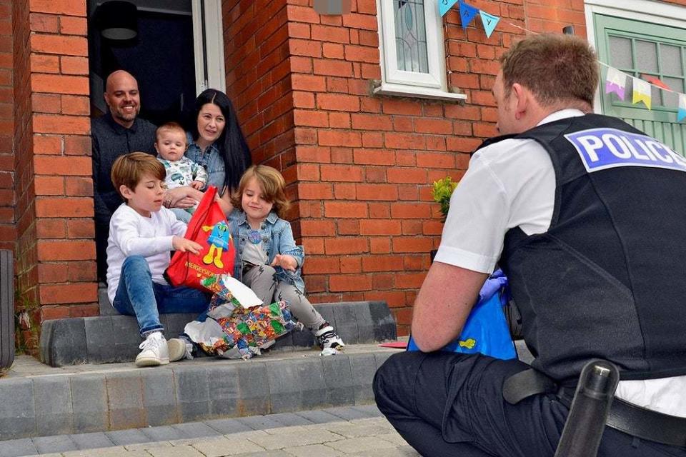 Dexter Lee, with parents Anna and Rob Lee, big brother Freddie and baby brother Mason, being greeted by Sergeant Mark Wilson (PA)