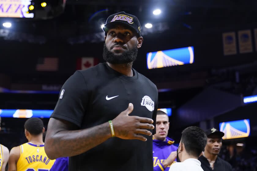 Los Angeles Lakers forward LeBron James stands on the court before a basketball game.