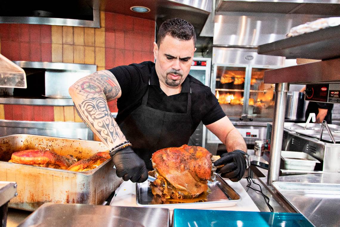 Randy Hernandez, one of the co-founders of the new Lechon Latin BBQ Joint in Raleigh’s Triangle Town Center, removes lechon from the oven before the restaurant’s soft opening on Friday, Jan. 14, 2022.