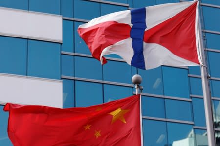 A Chinese national flag and Swire Group flag are seen in Hong Kong, China