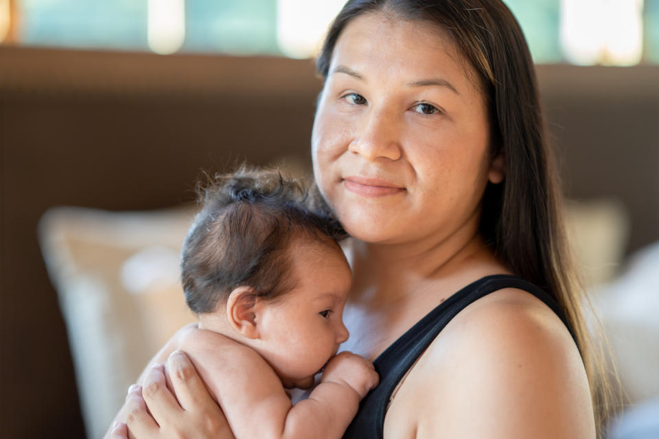 A mother holding her baby close, both looking content and calm