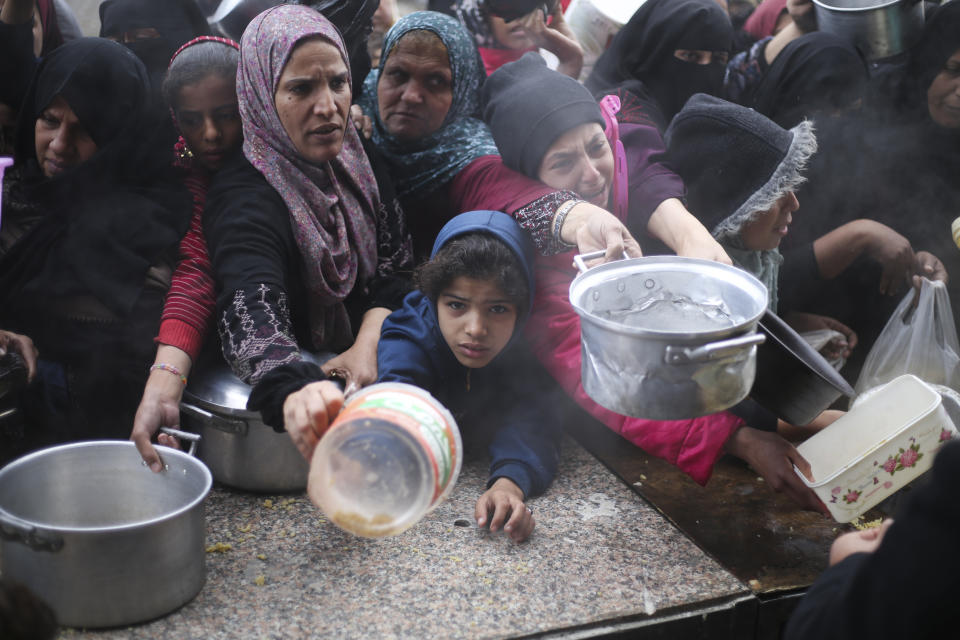 Palestinians line up for free food distribution during the ongoing Israeli air and ground offensive in Khan Younis, Gaza Strip, Friday, Feb. 2, 2024. (AP Photo/Hatem Ali)