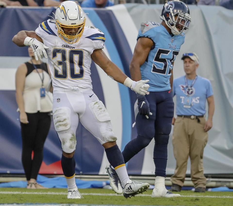 Chargers running back Austin Ekeler (30) celebrates a touchdown against Tennessee with an air guitar move.