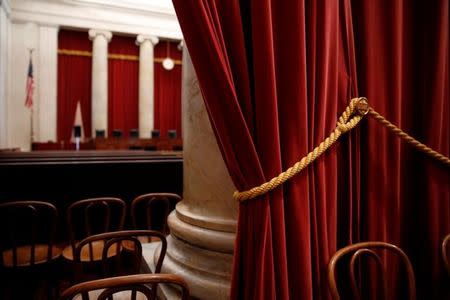 Red velvet drapes hang at the back of the courtroom at the U.S. Supreme Court building in Washington, U.S. June 20, 2016. REUTERS/Jonathan Ernst/Files