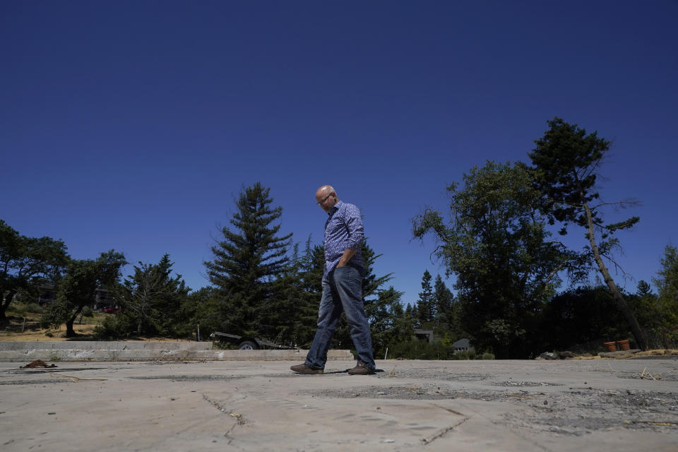 Will Abrams walks on the lot of his family home that was destroyed by wildfires in 2017 while interviewed in Santa Rosa, Calif., Thursday, June 24, 2021. Pacific Gas & Electric's CEO is pledging that the future will get “easier” and “brighter.” But those words are ringing hollow one year after PG&E emerged from a complex bankruptcy triggered by a succession of harrowing wildfires ignited by its long-neglected electrical grid. (AP Photo/Jeff Chiu)