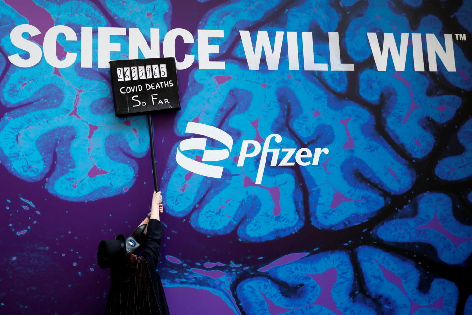 A demonstrator, wearing a beak doctor mask, holds up a sign at Pfizer's headquarters building, during a protest demanding just global distribution of COVID-19 vaccines during the coronavirus pandemic in New York City, U.S., March 11, 2021. REUTERS/Shannon Stapleton     TPX IMAGES OF THE DAY