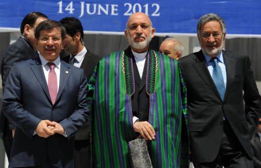 Afghan President Hamid Karzai (C) poses with Turkish Foreign Minister Ahmet Davutoglu (L) and his Afghan counterpart Zalmai Rasool (R) at the conclusion of the Heart of Asia Ministerial Conference at the Foreign Affairs Ministry in Kabul