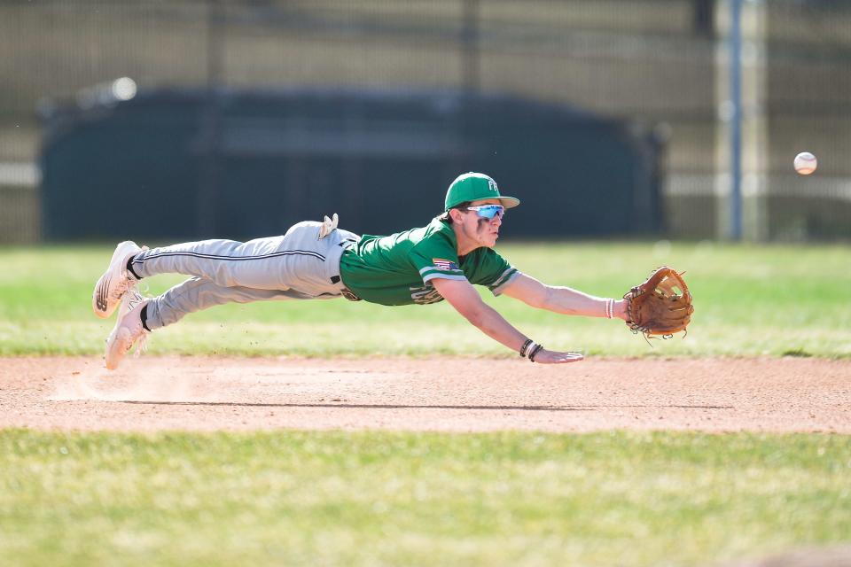 Fossil Ridge's Ethan Moran (1) dives for a weak popup during a high school baseball game against Fort Collins at Fort Collins High School on April 18, 2023.