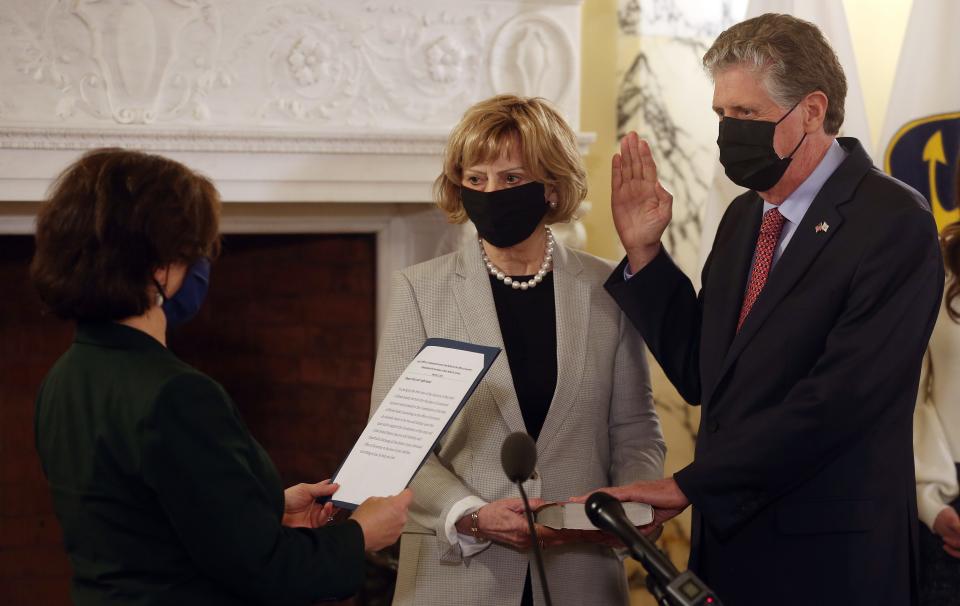 Dan McKee is sworn in as governor by Secretary of State Nellie Gorbea  at the Rhode Island State House last March.