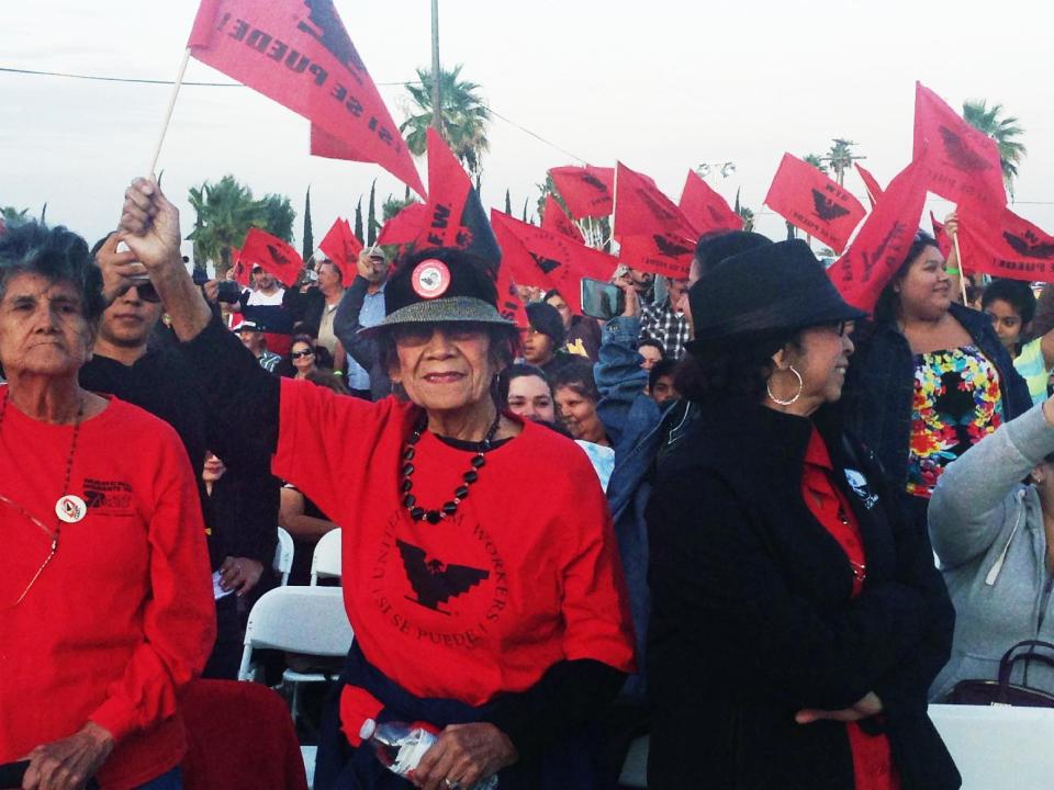 In this Tuesday, March 25, 2014 file photo, farm workers from California's Central Valley wave the United Farm Workers flag at a special screening of the film "Cesar Chavez" held at The 40 Acres, the former UFW headquarters in Delano, Calif. The location is now a national historic landmark. "Cesar Chavez" opens in theaters Friday, March 28, 2014. (AP Photo/Sandy Cohen)