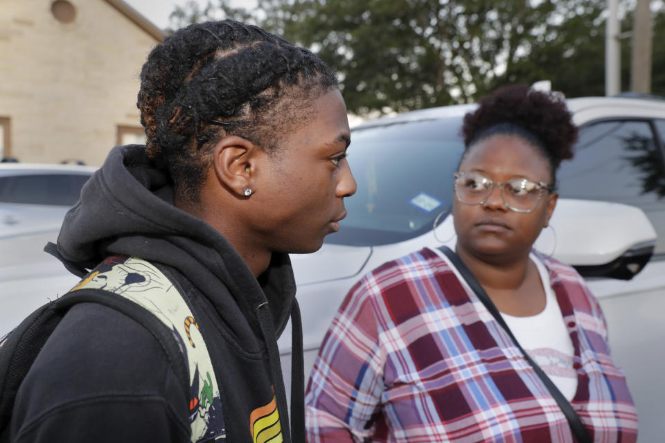 Darryl George, left, a 17-year-old junior, and his mother Darresha George, right, talks with reporters before walking across the street to go into Barbers Hill High School after Darryl served a 5-day in-school suspension for not cutting his hair Monday, Sept. 18, 2023, in Mont Belvieu. (AP Photo/Michael Wyke)