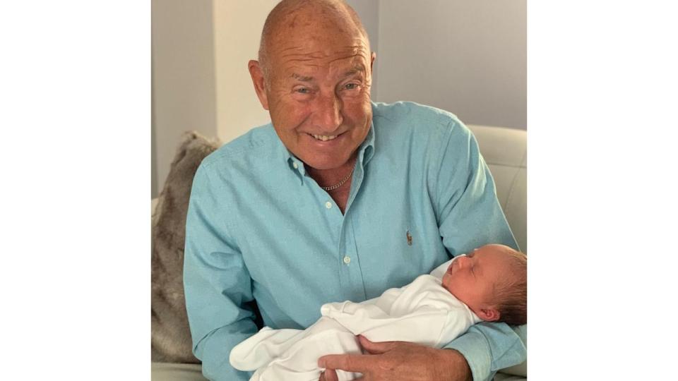 Elderly man holding a baby