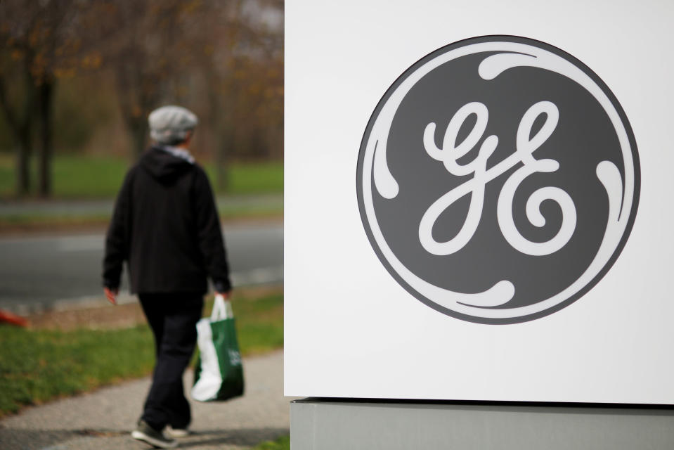A pedestrian walks past a General Electric (GE) facility in Medford, Massachusetts, U.S., April 20, 2017. GE will be leaving the Dow next week after more than 110 years of continuous membership in the index. REUTERS/Brian Snyder/File Photo