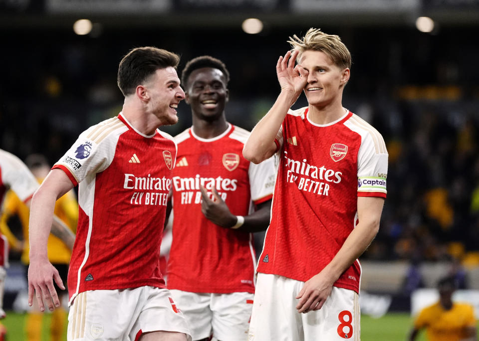 Arsenal's Martin Odegaard, right, celebrates scoring their side's second goal during the English Premier League soccer match between Wolverhampton Wanderers and Arsenal at the Molineux Stadium in Wolverhampton, England, Saturday, April 20, 2024. (Nick Potts/PA via AP)