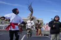 Perfomers from POOR Magazine and Deecolonize Academy dance in a parking lot, the only undeveloped portion of the shellmound in West Berkeley where ancestors of today's Ohlone people established the first human settlement on the shores of the San Francisco Bay, in Berkeley, Calif., Wednesday, March 13, 2024. Berkeley's City Council voted unanimously Tuesday, March 12, 2024, to adopt an ordinance giving the title of the land to the Sogorea Te' Land Trust, a women-led, San Francisco Bay Area collective that works to return land to Indigenous people and that raised the funds needed to reach the agreement. (AP Photo/Jeff Chiu)