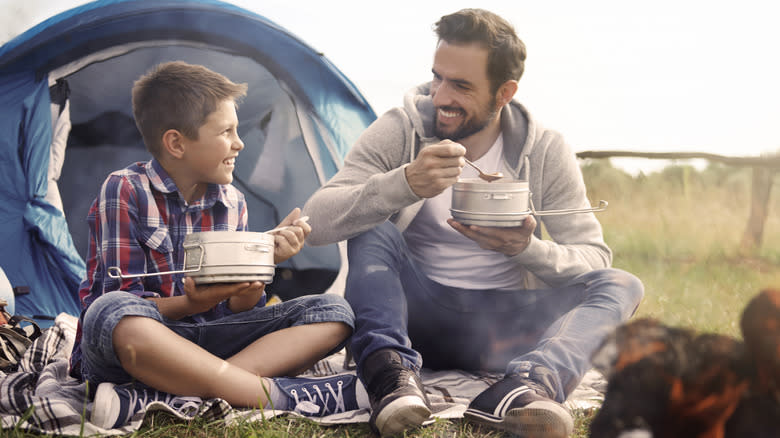 father son eat at campsite