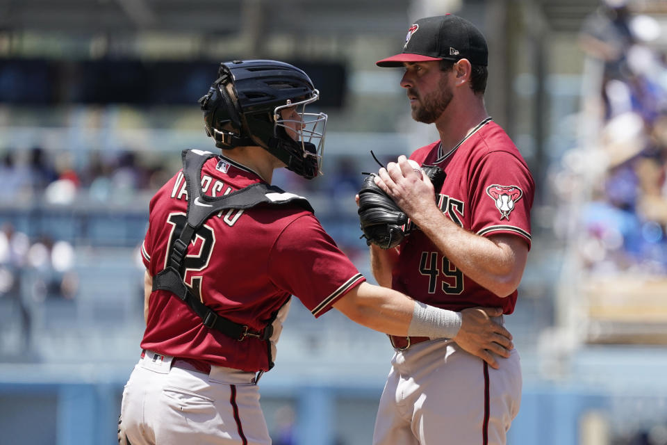 Arizona Diamondbacks starter Tyler Gilbert, right, gets a visit to the mound by catcher Daulton Varsho (12) after Gilbert gave up a solo home run to Los Angeles Dodgers' Trea Turner during the sixth inning of the first game of a baseball double-header Tuesday, May 17, 2022, in Los Angeles. (AP Photo/Marcio Jose Sanchez)