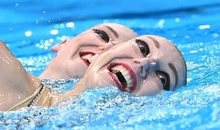 A close-up of their exaggerated smiles and dramatic eye makeup and lipstick