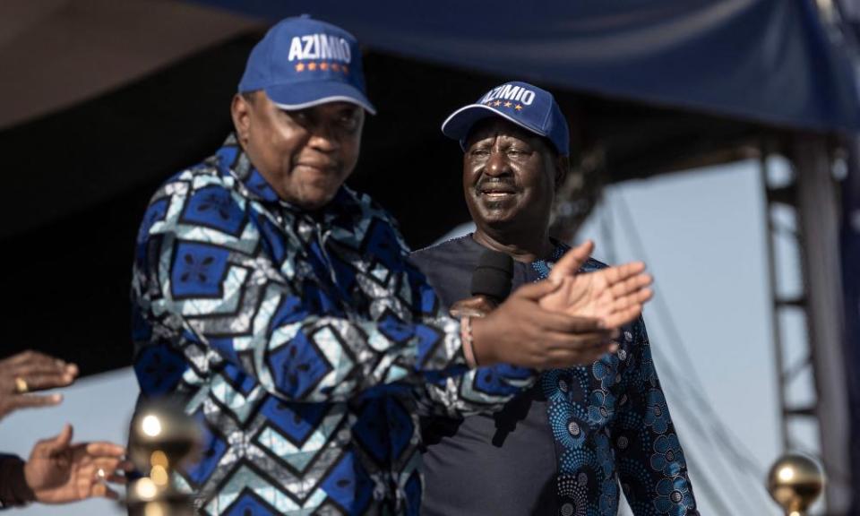 Kenya’s president, Uhuru Kenyatta, left, claps as he does a jig to a popular campaign jingle on a podium next to his former political nemesis, Raila Odinga, right.
