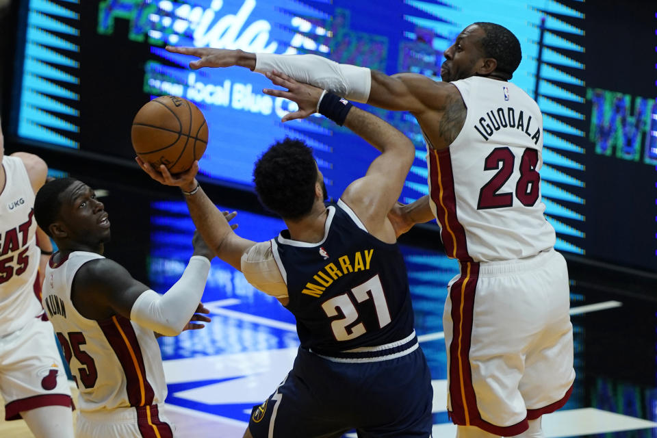 Miami Heat forward Andre Iguodala (28) blocks a drive to the basket by Denver Nuggets guard Jamal Murray (27) during the second half of an NBA basketball game, Wednesday, Jan. 27, 2021, in Miami. (AP Photo/Marta Lavandier)