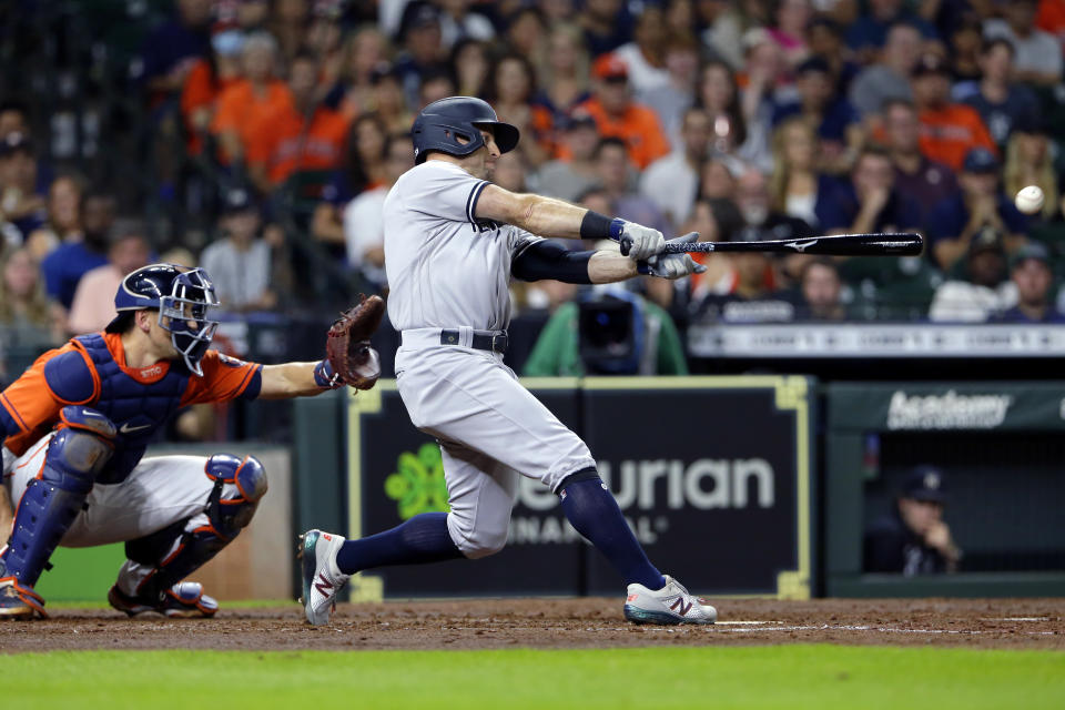 New York Yankees' Gio Urshela hits a two-run single in front of Houston Astros catcher Jason Castro during the fourth inning of a baseball game Friday, July 9, 2021, in Houston. (AP Photo/Michael Wyke)