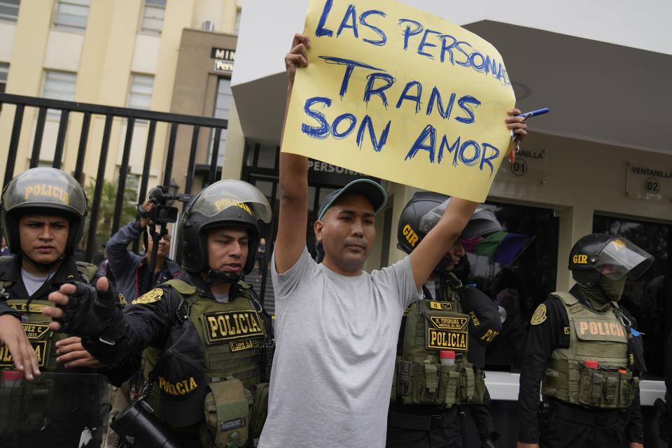 Un manifestante de la comunidad LGBTI+ con un cartel a favor de las personas trans en una protesta contra un decreto del gobierno de Perú que clasifica siente identidades de género como enfermedades mentales, en Lima, Perú, el viernes 17 de mayo de 2024. (AP Foto/Martín Mejía)