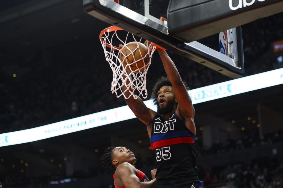 Detroit Pistons forward Marvin Bagley III (35) dunks while Toronto Raptors forward Scottie Barnes (4) looks on during the first half of an NBA basketball game in Toronto on Sunday, Nov. 19, 2023. (Christopher Katsarov/The Canadian Press via AP)