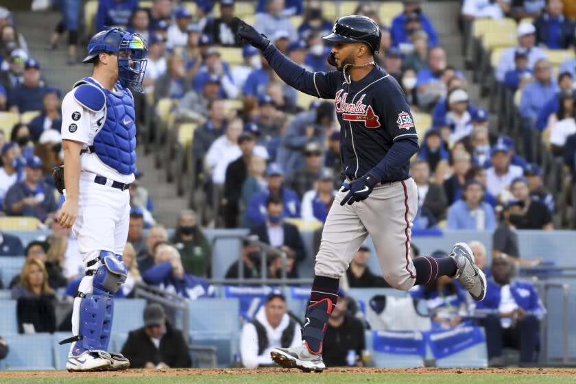 Braves' Eddie Rosario runs past home to score a run off a solo home run past Dodgers catcher Will Smith