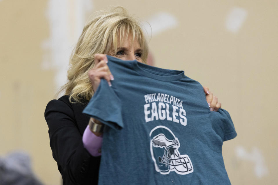 FILE - First lady Jill Biden holds up a Philadelphia Eagles shirt while sorting children's clothes at the FEMA State Disaster Recovery Center in Bowling Green, Ky., Jan. 14, 2022. (AP Photo/Michael Clubb, File)