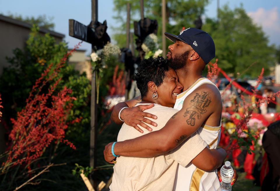 May 8, 2023: Robert Jackson comforts his mother Cheryl Jackson as they visit a memorial near the scene of a mass shooting at the Allen Premium Outlets mall in Allen, Texas. Eight people were killed in the Saturday attack in which the gunman was killed by police, according to published reports.