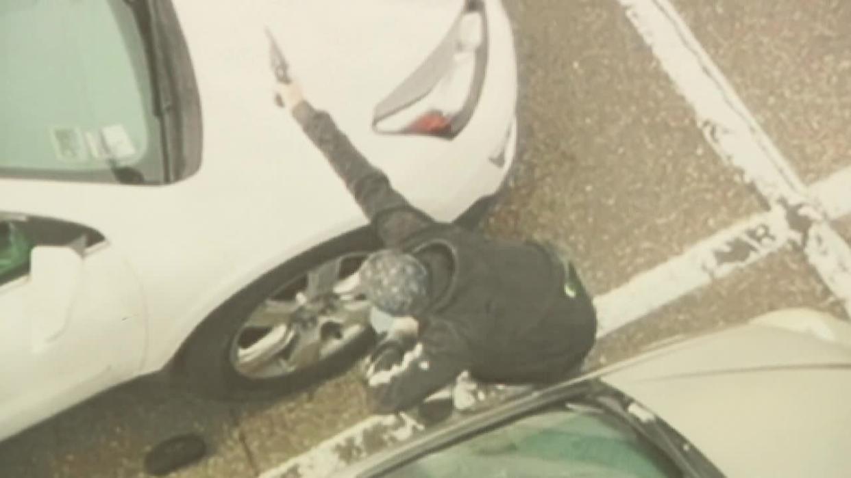<div>A photo from Woodbury police, that appears to have been captured by a drone, shows Roche crouching between two vehicles pointing what was later found to be a BB gun.</div>