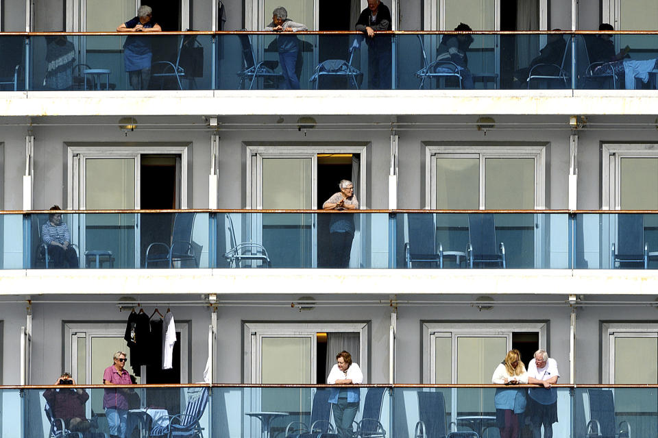 Passengers look out from balconies aboard the Grand Princess as it cruises a holding pattern about 25 miles off the coast of San Francisco on Sunday, March 8, 2020. The ship is expected to dock in Oakland in the east San Francisco Bay on Monday. California Gov. Gavin Newsom and the mayor of Oakland sought Sunday to reassure the public that none of the passengers from the ship with multiple cases of the new coronavirus will be released into the public before undergoing a 14-day quarantine. (AP Photo/Noah Berger)