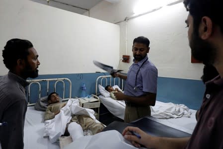 Doctores pay visit to men who were injured during an earthquake at the Divisional Headquarters Teaching Hospital Mirpur