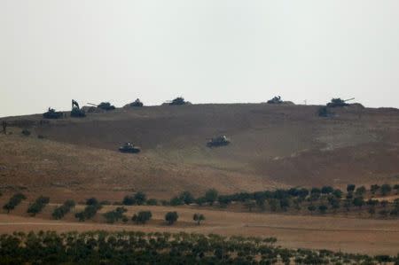 Turkish army tanks are stationed on a hill in the Syrian border town of Jarablus as they are pictured from the Turkish town of Karkamis, in the southeastern Gaziantep province, Turkey, August 24, 2016. REUTERS/Umit Bektas