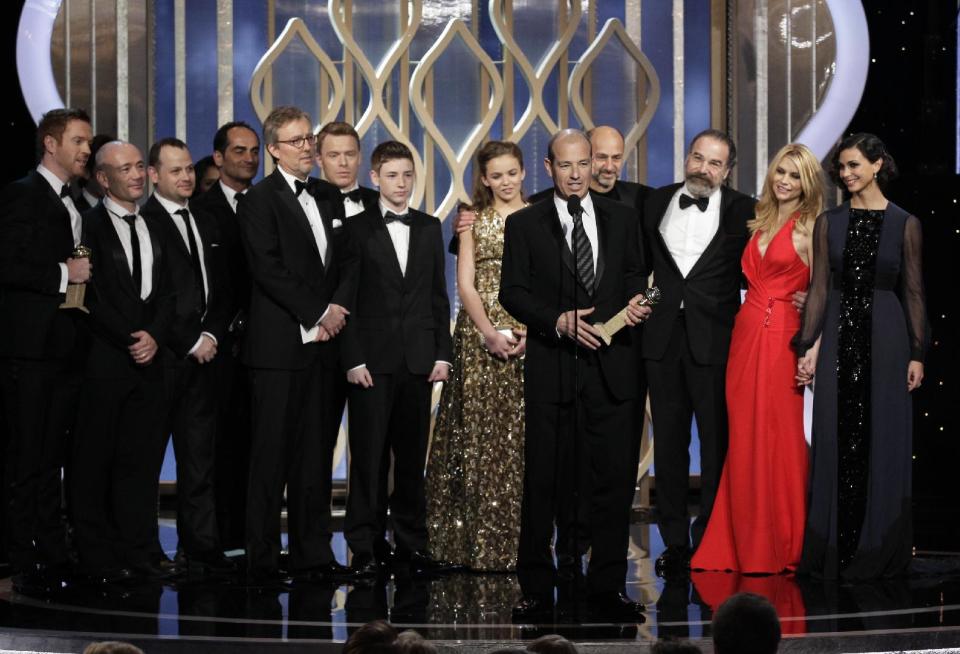 This image released by NBC shows Executive Producer Howard Gordon, foreground, accepting the award for best TV drama series for "Homeland" during the 70th Annual Golden Globe Awards at the Beverly Hilton Hotel on Jan. 13, 2013, in Beverly Hills, Calif. (AP Photo/NBC, Paul Drinkwater)