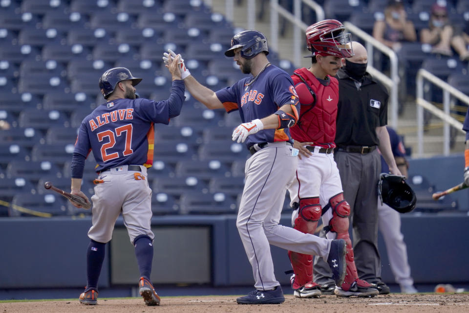 Houston Astros' Steven Souza Jr., center, is congratulated by teammate Jose Altuve, left, as Washington Nationals catcher Tres Barrera, right, stands by after Souza hit a two-run home run during the fourth inning of a spring training baseball game Monday, March 1, 2021, in West Palm Beach, Fla. (AP Photo/Jeff Roberson)
