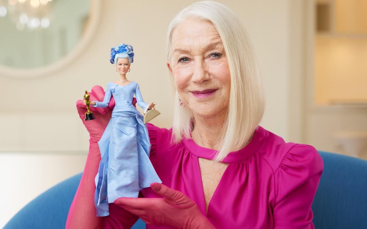 Dame Helen Mirren holding her one-of-a-kind Barbie