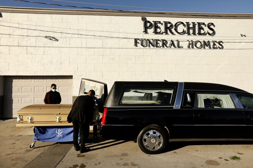 Dr. David González Velazco, left, beside his brother-in-law's casket outside Perches Funeral Home in Juarez, Mexico.