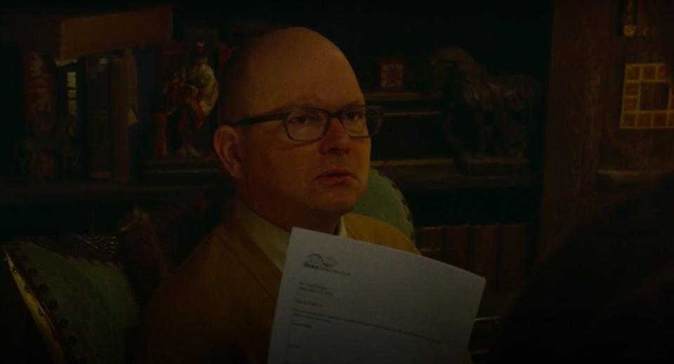 Colin Robinson holding up his ancestry report in "What We Do in the Shadows"