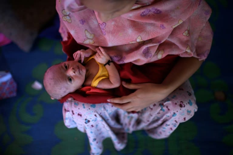 Johara Begum holds her five-day-old baby boy Mohammad Anas, who was delivered with the help of a neighbouring midwife, in the shelter she shares with her husband and family at the Jamtoli refugee camp near Cox's Bazar