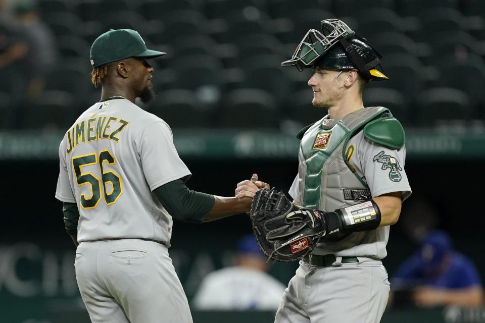 Oakland Athletics' Dany Jimenez and catcher Sean Murphy celebrate the team's 5-1 win in a baseball game against the Texas Rangers in Arlington, Texas, Tuesday, Aug. 16, 2022. (AP Photo/Tony Gutierrez)