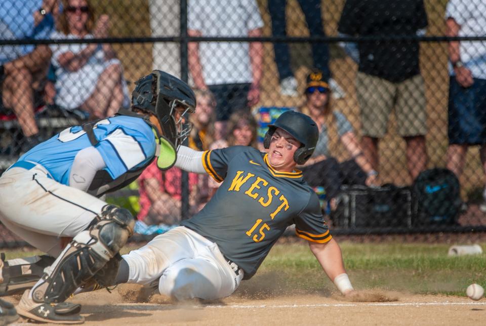 Central Bucks West's Sam Greer slides safely into home plate as North Penn catcher Brady Dolder attempts to make the tag Tuesday.