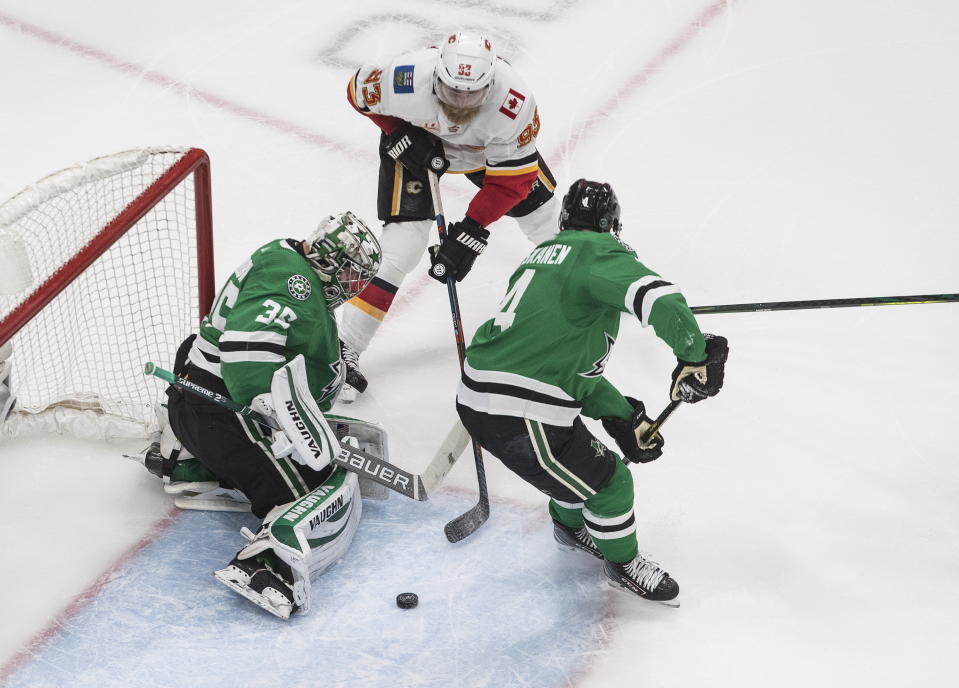 Calgary Flames' Sam Bennett (93) is stopped by Dallas Stars' goalie Anton Khudobin (35) as Miro Heiskanen (4) defends during second period NHL Western Conference Stanley Cup playoff hockey action in Edmonton, Alberta, Tuesday, Aug. 18, 2020. (Jason Franson/The Canadian Press via AP)